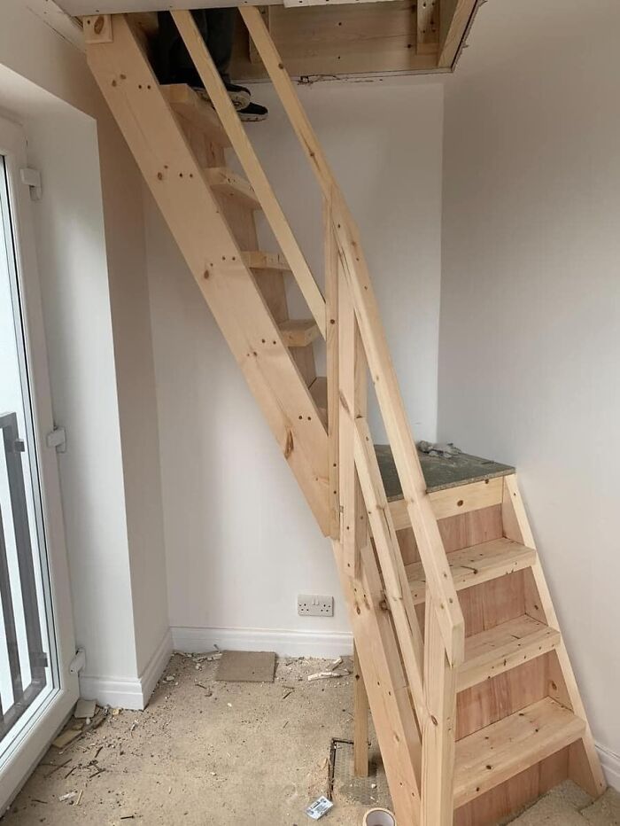 Wooden staircase leading to a blocked ceiling, illustrating a funny construction fail.