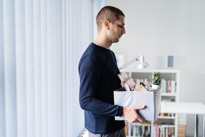 Man carrying a box of items at home, highlighting partner's weird habits after moving in together.