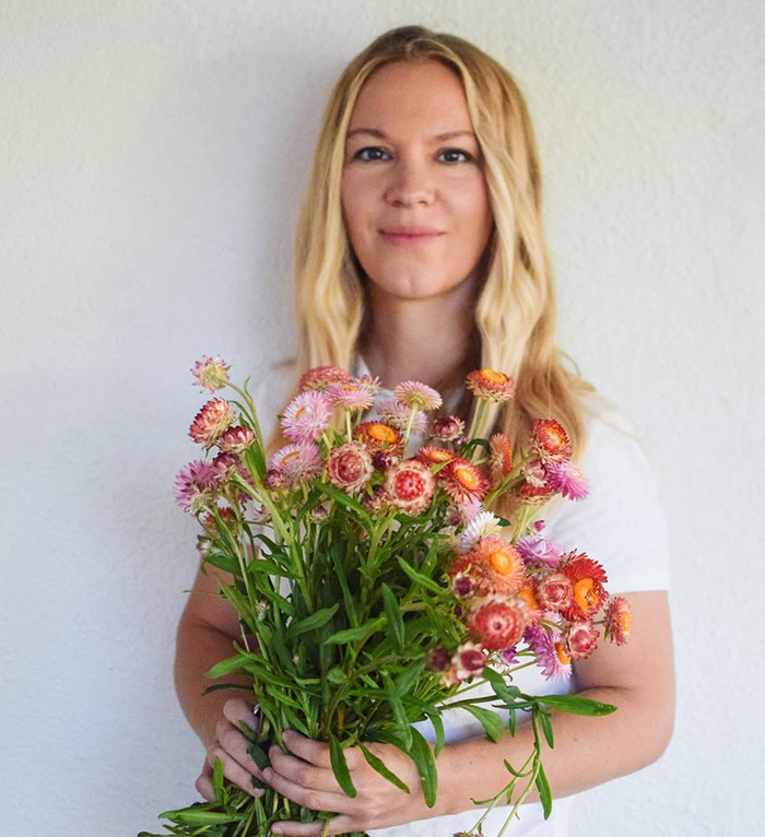  Jenna Miscavige holding colorful flowers against a plain background, related to ex-Scientologist discussions.