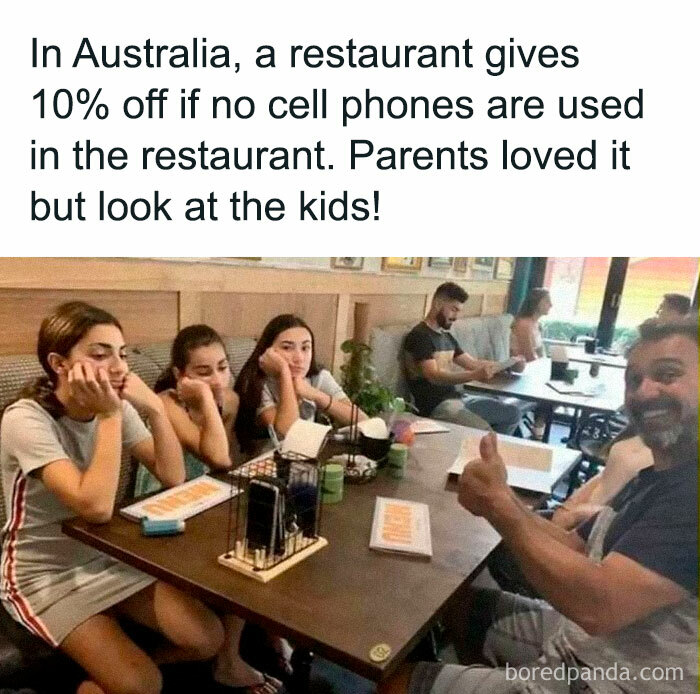 "Family sitting at a restaurant table with phones away, enjoying a discount in Australia."