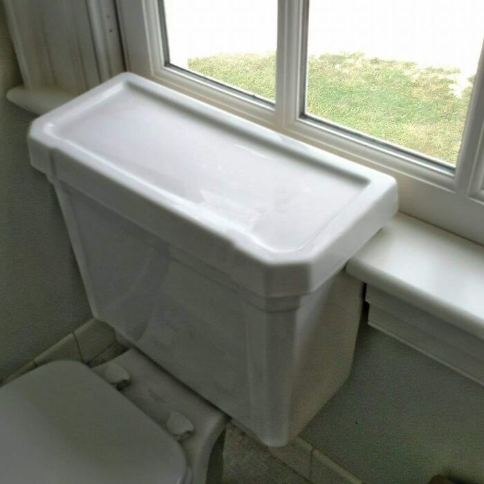 Toilet tank blocking window sill, demonstrating a funny construction fail.