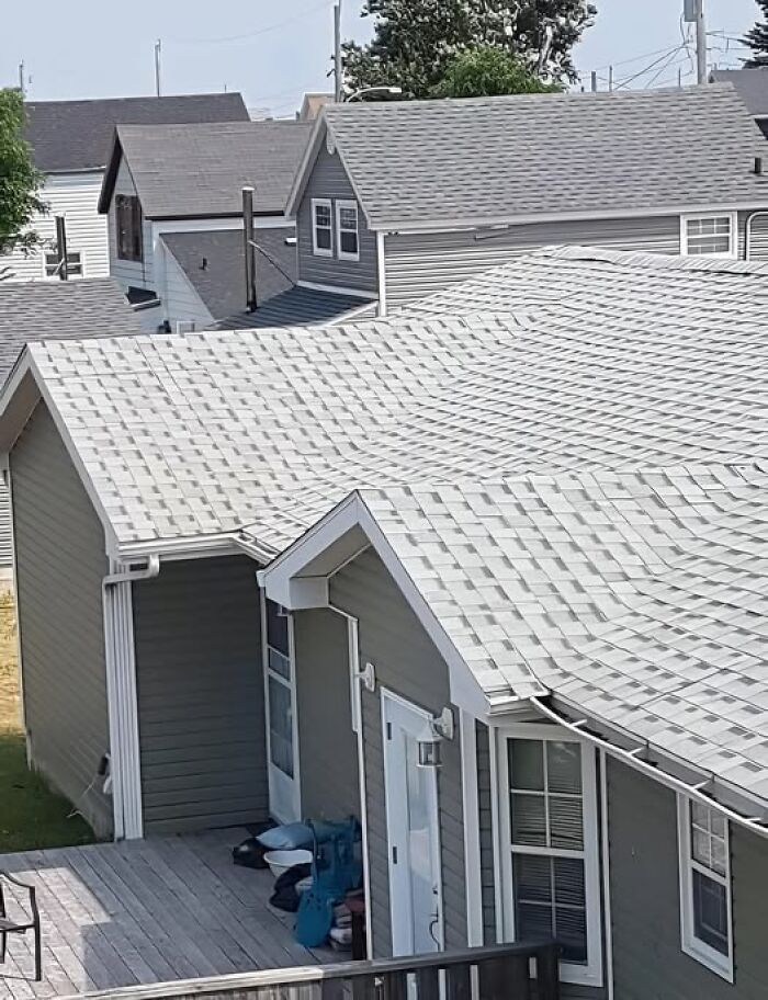 Rooftop with shingles leading awkwardly onto another roof, illustrating a cheap construction fail.