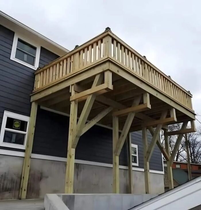 Wooden deck constructed awkwardly on a house, illustrating funny cheap construction fails.