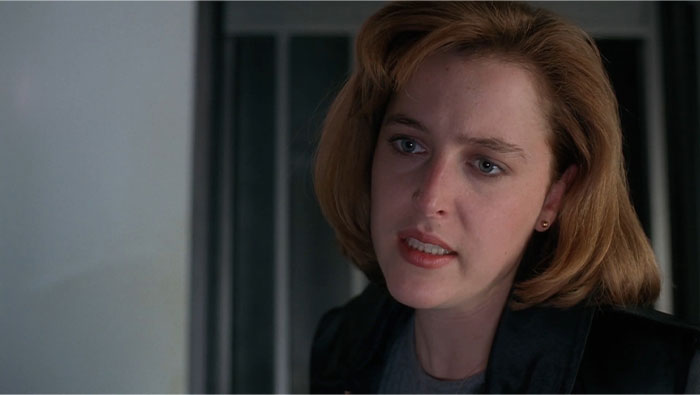 Close-up of a serious woman with short, light brown hair, embodying a strong female protagonist.