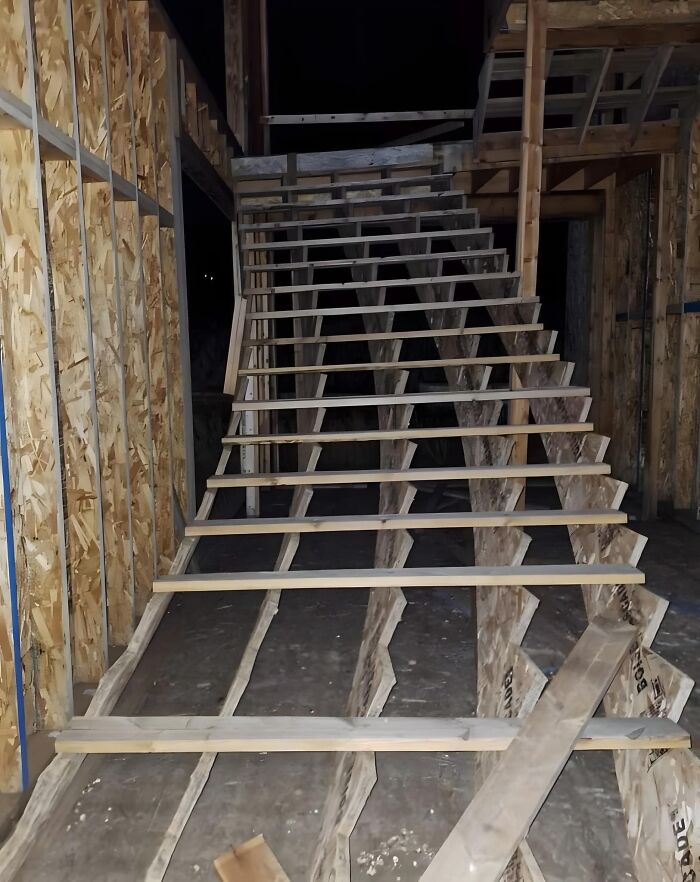 Slanted wooden stairs in a construction site, showcasing a funny cheap construction fail.