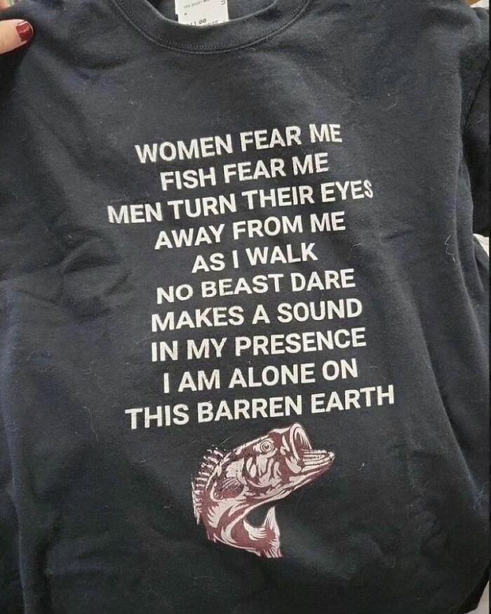 Black shirt with humorous text about being feared by women, fish, and beasts; features a fish graphic. 