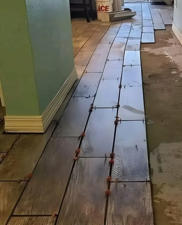 Uneven floor tiles misaligned in a hallway showcasing cheap construction fails.