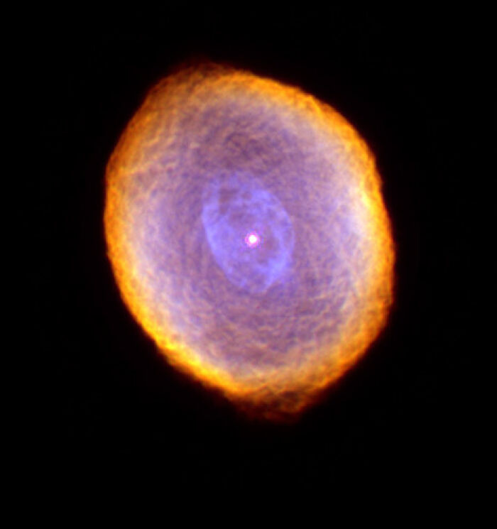 Vibrant nebula in space, displaying glowing rings of orange and blue.