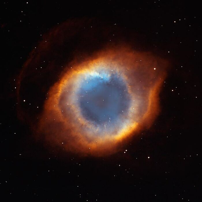 Colorful Helix Nebula against a starry sky, showcasing vibrant blue and orange gases. Perfect example of amazing nebula pics.