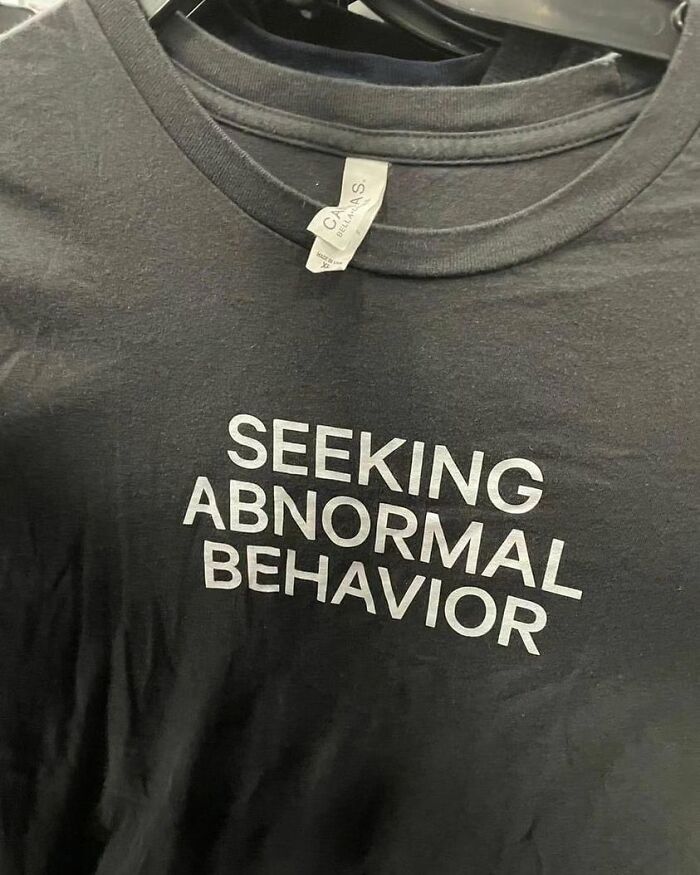 Black shirt with "Seeking Abnormal Behavior" text, an example weird shirts.