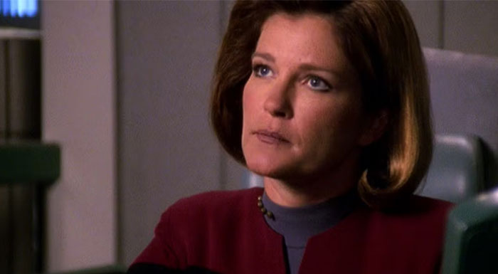 Woman in uniform sitting pensively, exemplifying a strong female protagonist in a sci-fi setting.