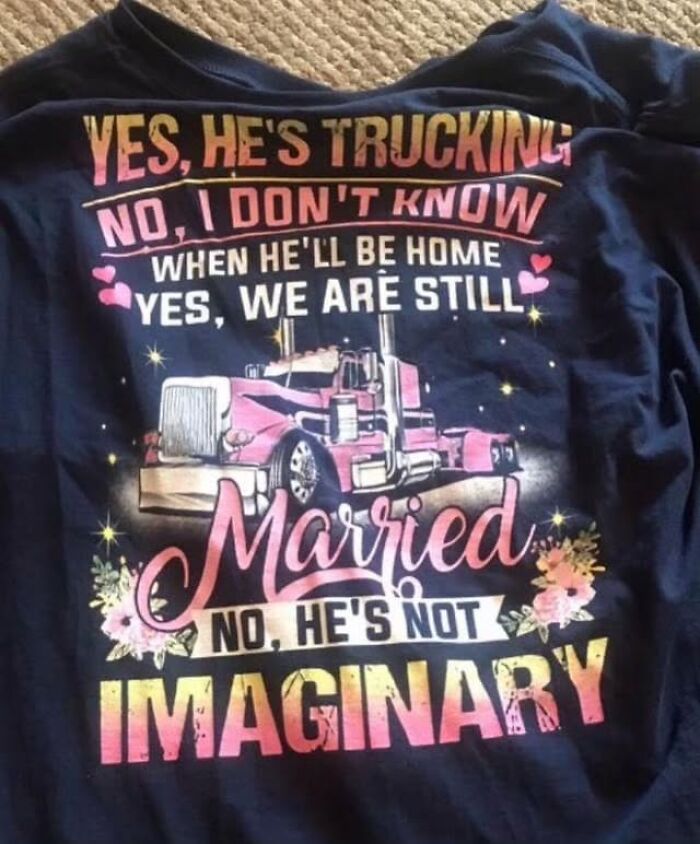 Blue shirt with colorful text and a truck design, joking about quirky relationship status. 