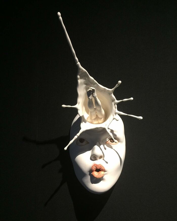 Surrealistic sculpture featuring a splash design on a realistic face, highlighting expressive art techniques.