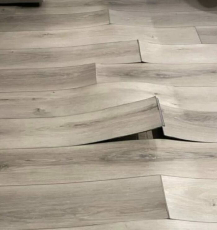 Warped wooden flooring panels demonstrating a cheap construction fail.