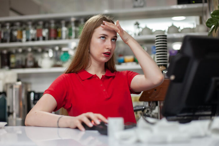 A stressed employee at a cafe counter, illustrating crazy stories of HR challenges.