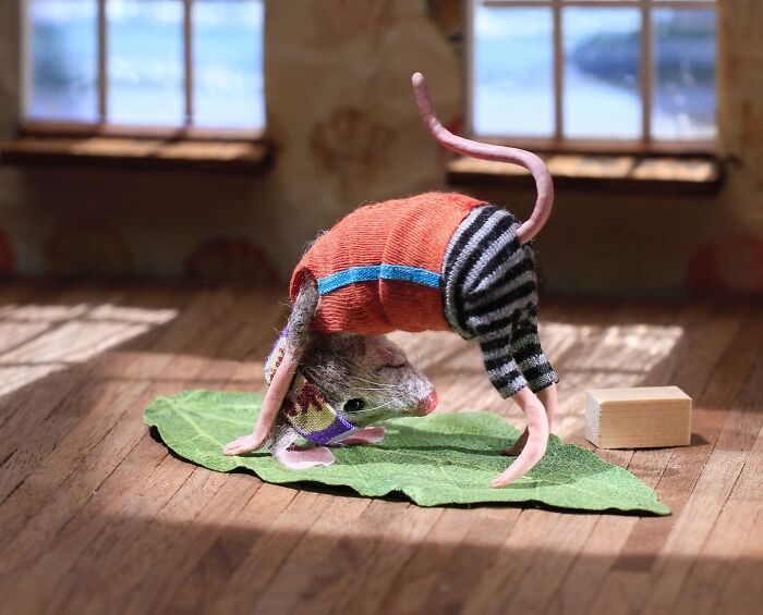 A miniature mouse in striped pants doing a handstand on a leaf in Mouseland.