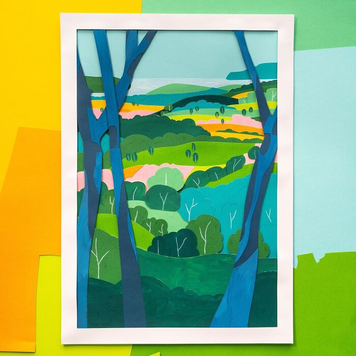 Layered paper illustration depicting a vibrant landscape with trees and hills.