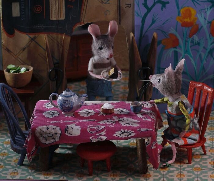 Miniature mice sitting at a table in a charming, detailed Mouseland scene by Maggie Rudy.