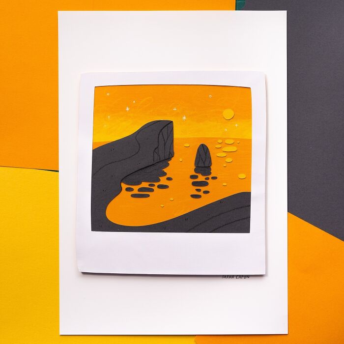 Layered paper illustration of a sunset seascape with rocks and reflections in warm orange hues.