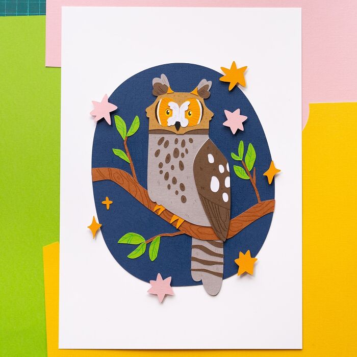 Layered paper owl illustration with colorful stars and leaves on a branch.