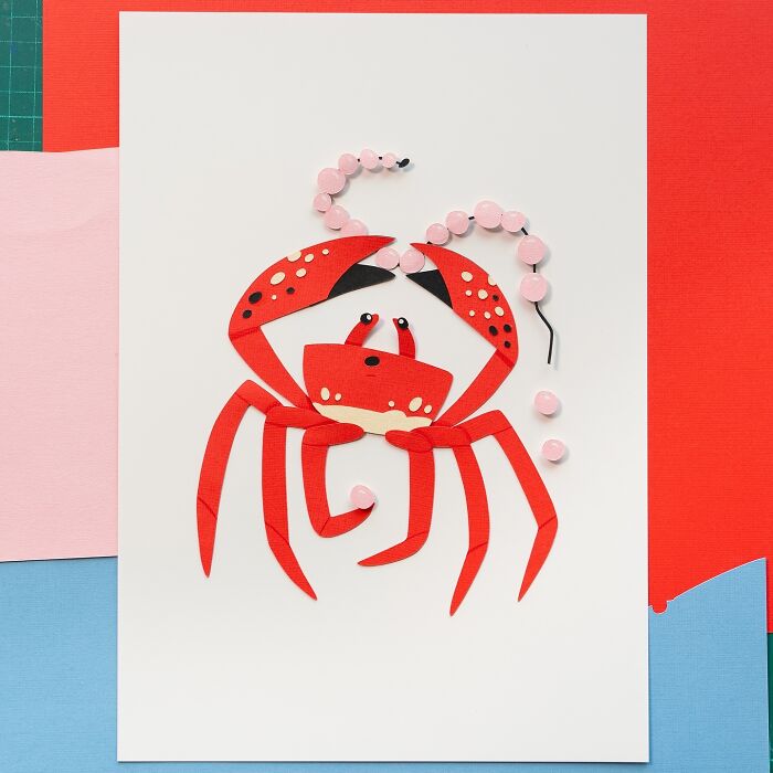 Layered paper art of a cute red crab illustration on colorful background.