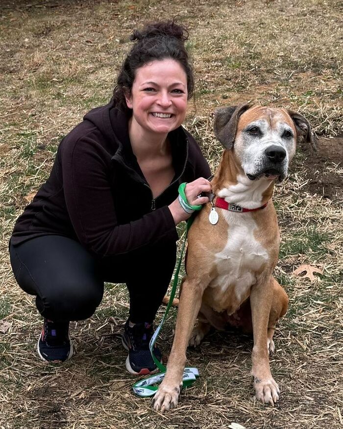 A woman smiles alongside a 12-year-old rescued pup ready for adoption.