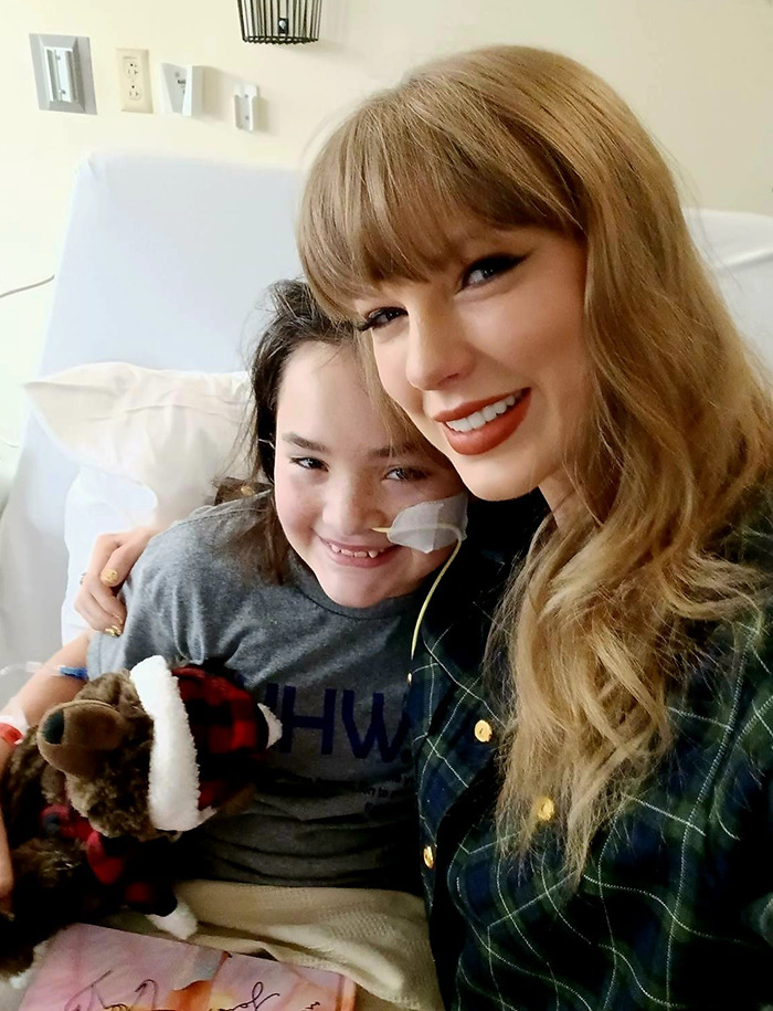 Taylor Swift smiles with a young patient in a children\'s hospital visit.