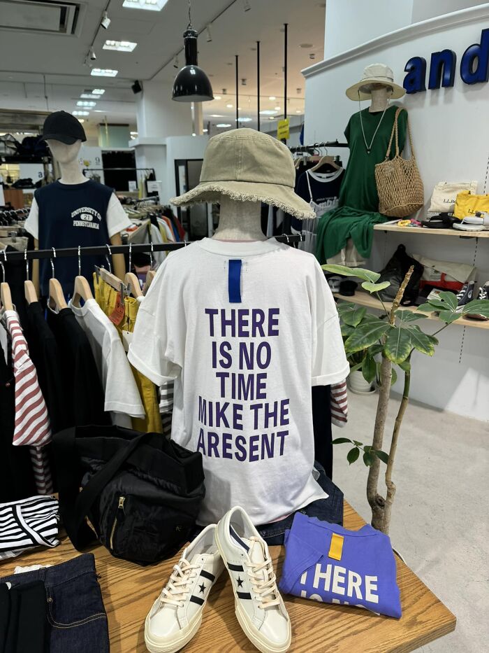 T-shirt with funny translation: "THERE IS NO TIME MIKE THE ARE SENT" displayed in a Japanese clothing store.