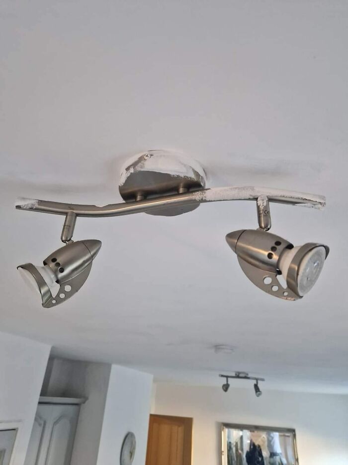 Ceiling spotlight fixture bent out of shape, showcasing a funny cheap construction fail.