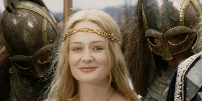 A strong female protagonist in medieval armor, smiling, flanked by two helmeted warriors.