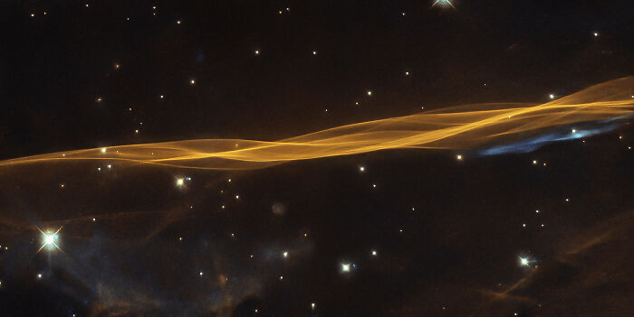 Stunning image of a nebula with bright stars and glowing filaments in deep space.