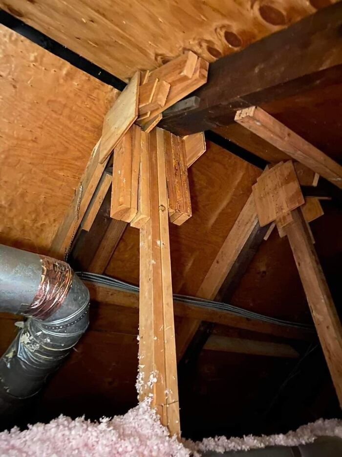 Funny cheap construction fail with poorly aligned wooden beams in an attic.