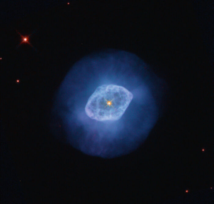 Blue-hued nebula with a bright star at its center, surrounded by deep space and distant stars.