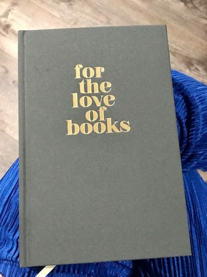 Gray book titled "for the love of books" on a blue fabric background.