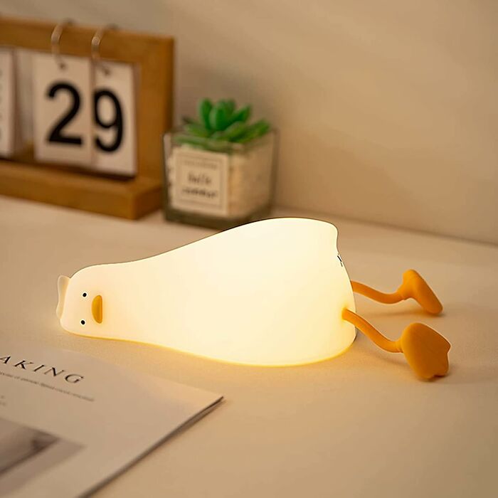 Quirky duck-shaped lamp on a desk, ideal for antisocial people seeking unique gifts.