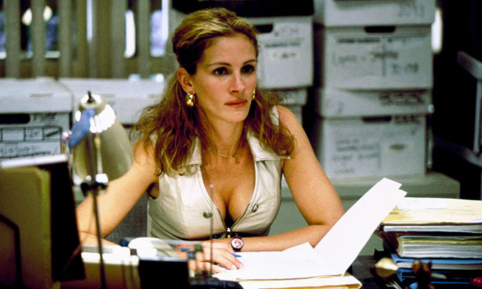 Strong female protagonist in an office setting, focused and determined, surrounded by files.