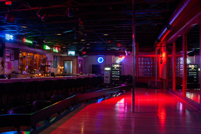 Neon-lit bar with empty stools, showcasing nightlife setting.