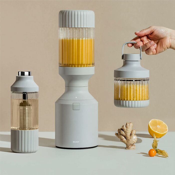 Modern kitchen blender and smoothie jars, perfect gifts for your mom, with ginger, lemon, and berries displayed.