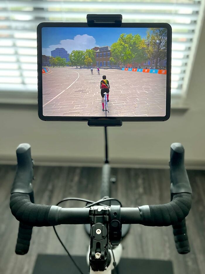 Indoor bike with a screen showing a virtual cycling route, ideal gift for antisocial people seeking solo exercise.