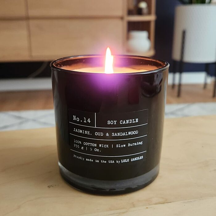 Soy candle with jasmine, oud, and sandalwood, perfect gift for antisocial people, creating a cozy atmosphere at home.