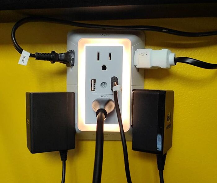 Power outlet with multiple plugs and USB ports, a Reddit room upgrade with a glowing backlight against a yellow wall.