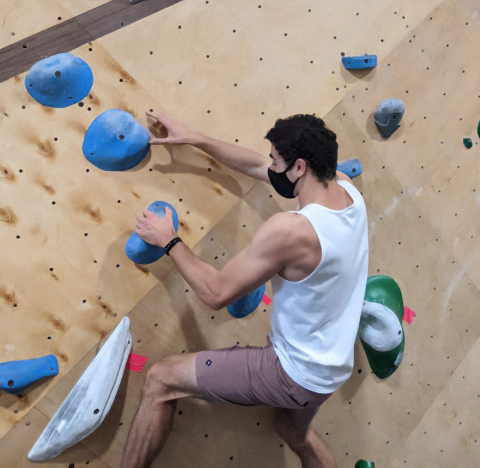 Luigi Mangione in a mask bouldering indoors, reflecting compassionate nature despite recent arrest.