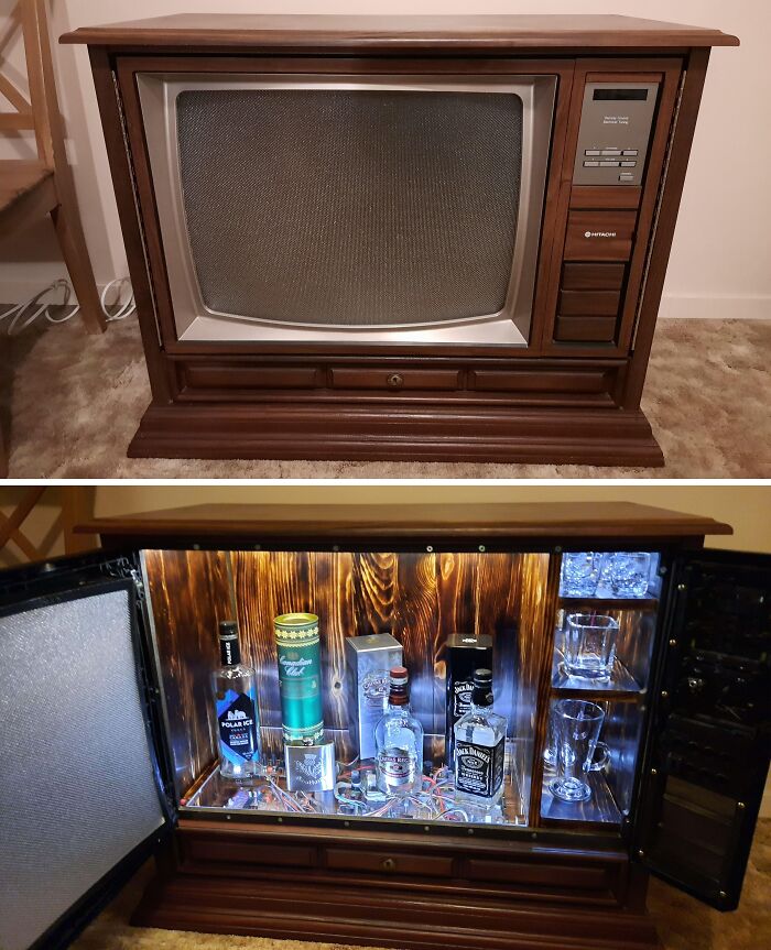 Restored vintage TV cabinet transformed into a stylish liquor bar with bottles and glasses displayed inside.