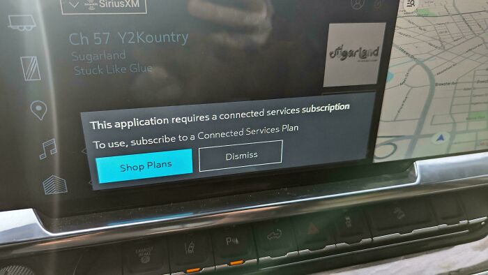 Car dashboard display showing a deceptive-marketing-techniques message about a required subscription for services.