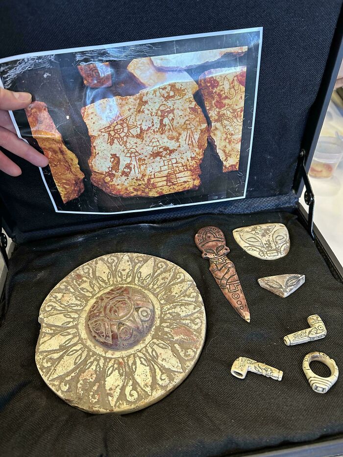 Ancient artifacts including a decorative plate, knife, and jewelry as a unique inheritance in a display case.