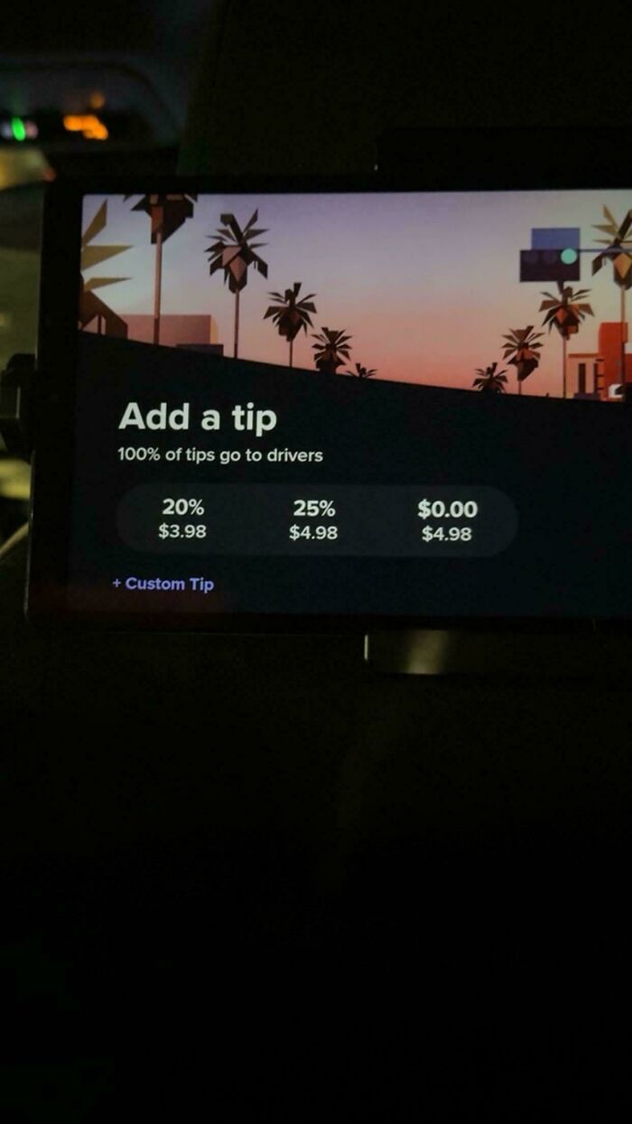 Tablet displaying a tipping screen in a rideshare car at night, demonstrating deceptive marketing techniques.