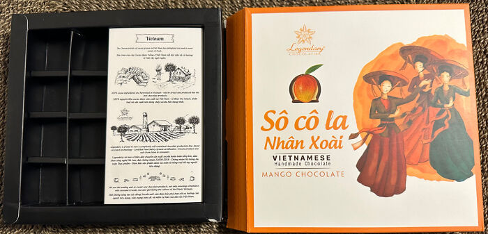 Misleading packaging design: an empty chocolate box with vibrant mango-themed cover art.