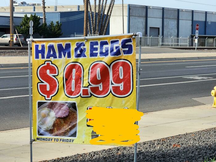 Sign advertising ham and eggs for $0.99, potential deceptive marketing with unclear value.