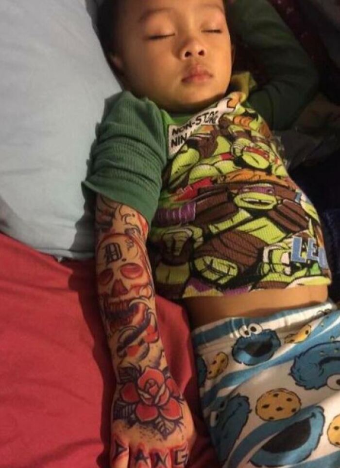 Child sleeping with temporary tattoo sleeve; hilarious in-laws prank.