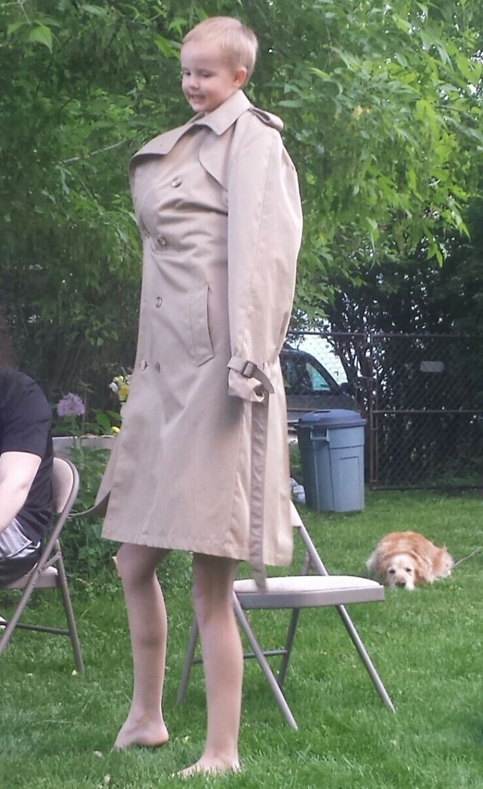 Child wearing an oversized trench coat, creating a humorous in-laws moment.